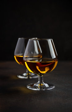 Glass of brandy or cognac on the old rusty background Selective focus