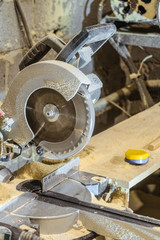 Disc electric circular saw. Sawing machine in a working carpentry workshop. Mechanized woodworking carpenter tool. Miter saw blade.