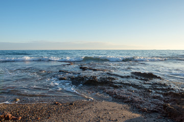 The calm sea in a very cloudy sunset