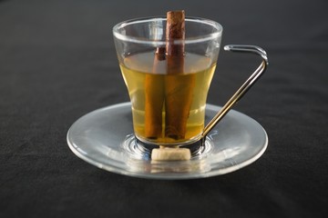 Glass cup of tea with cinnamon