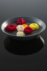 Red, white and yellow roses in glass bowl with water