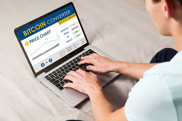 Bitcoin trading website. Man using a laptop to trade bitcoin price by internet.