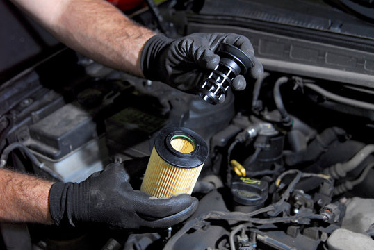 mechanic in the hand, remove car oil filter
