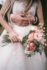 The bridegroom embraces the bride's waist,