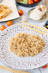 Chinese noodles on ceramic plate with chopsticks.