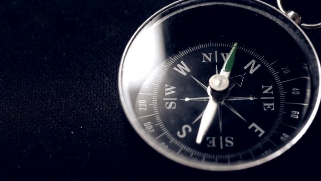 Navigation compass moving slowly closeup macro, loopable, black background