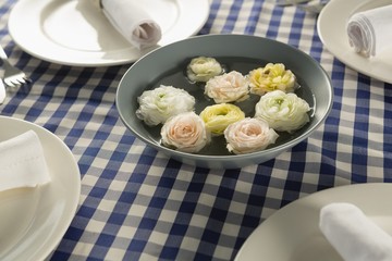 Rolled up napkin with flower decoration arranged on table