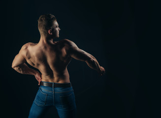 Fototapeta premium Athlete man with bare torso in blue jeans, back view