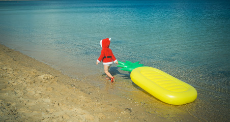 Santa claus kid in red Christmas costume.