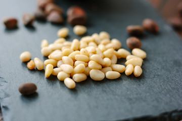 Clean pine nuts on black kitchen board.