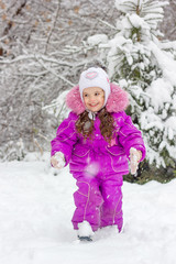 Winter activity - little girl playing snowballs.