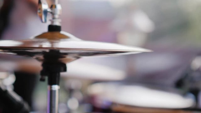 The drummer strikes with his chopsticks, close-up