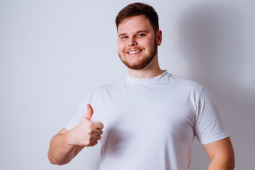 young cheerful man showing thumb up