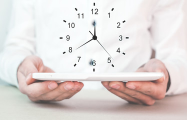 Businessman holding clock. Concept of saving time.