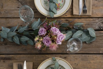 Plates with napkin, fork, butter knife and flower arranged on