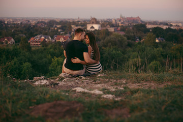 Young couple in love outdoor. Beautiful nature and warm sunset 