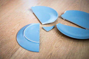 Bruchstück eines grauen Tellers auf Holzboden