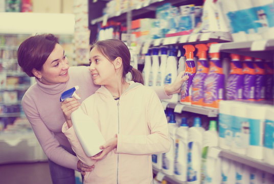 Smiling woman with daughter choosing cleaners