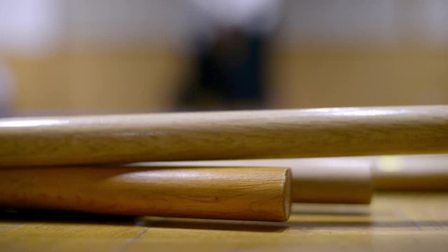 Aikido sticks jo and two aikido fighters in background
