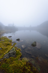 Fototapeta na wymiar misty morning view in wet mountain area in slovakian tatra. mountain lake panorama