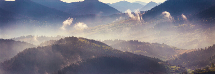 Spring mountain panorama. Foggy forest on hills