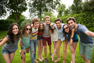 Group of young people standing in the grass, posing for a photo