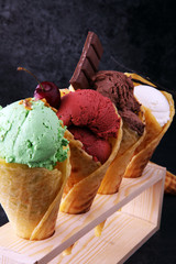 Set of ice cream scoops of different colors and flavours with berries, nuts and fruits