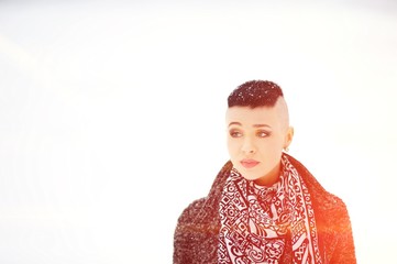 Portrait lovely cute girl with snowflakes on a short hair coat with a beautiful scarf on an white...