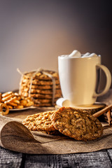 Winter autumn still life  homemade recipe honey ginger oatmeal cookie and bagel, cocoa cup coffee with marshmallow on wooden table kitchen