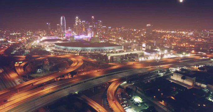 Aerial view city traffic freeway interchange night downtown Los Angeles skyline