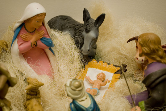 detail: Christmas nativity scene, for holidays, Mary closeup, jesus newborn baby in straw, around him the other statuettes, Mary, Joseph, Three Kings, pacors, ox and donkey, December, winter, Italy