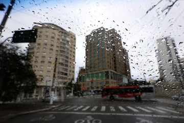 View, from windshield by car, of city on rainy day