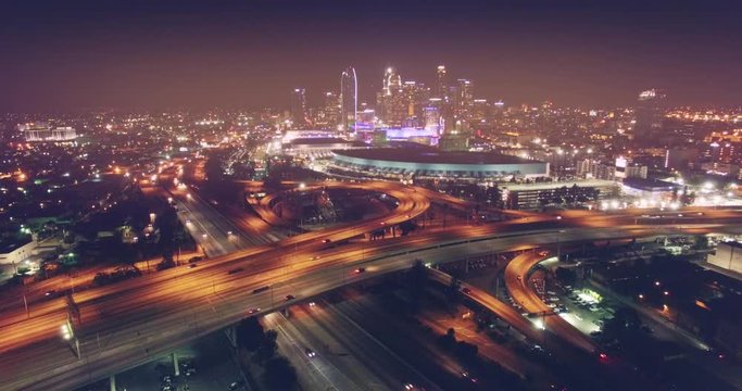 Los Angeles freeway interchange aerial view downtown skyline at night 4K UHD