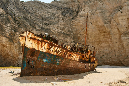 A rusty shipwreck on a rocky beach on Zakynthos Island.