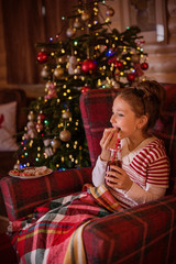 girl in a chair by a christmas tree