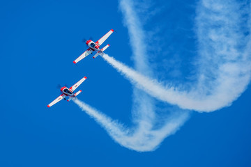 samoloty wykonujące akrobacje na błękitnym niebie - obrazy, fototapety, plakaty