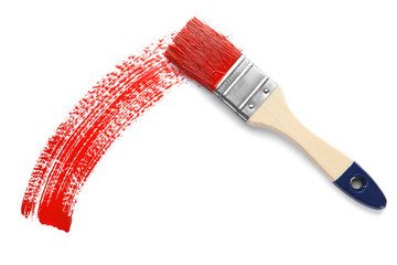 Brush and red paint stroke on white background, top view