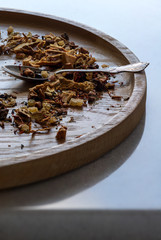 Fototapeta na wymiar Dried fruits and herbs on the wooden plate with silver spoon.