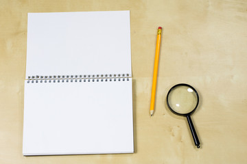 Drawing instruments and a notebook on the work table. Accessories for designing and sketching on a wooden drawing board.