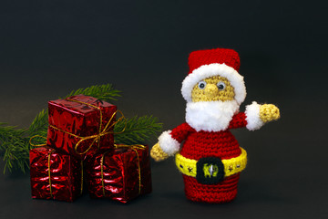 branches of a Christmas tree with gifts and a puppet Santa