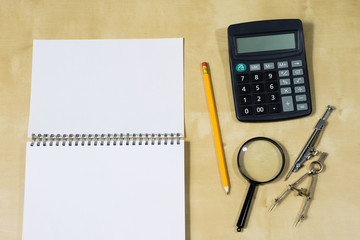Drawing instruments and a notebook on the work table. Accessories for designing and sketching on a...