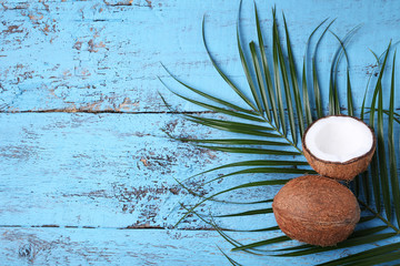 Fototapeta na wymiar Coconuts with leafs on blue wooden table