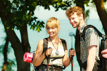 Two people tourists hiking by sea ocean.