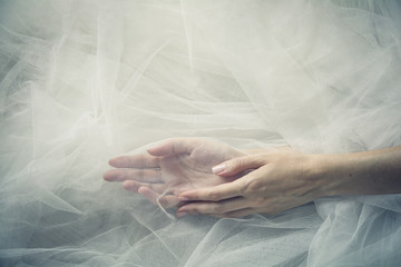 Sorority - A couple of female hands on a tulle background in a calm, relaxed mood