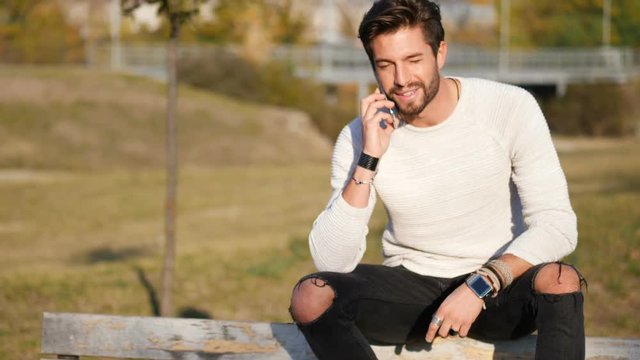 Handsome man making phone call outdoor in urban environment on with cell phone