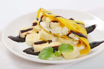 thin pancakes with banana and whipped cream