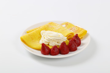 thin pancakes with strawberries and whipped cream