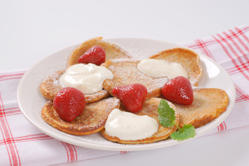 small pancakes with cream and strawberries