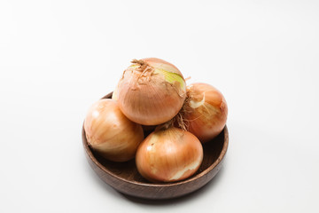 Fresh onions on a wood dish isolated