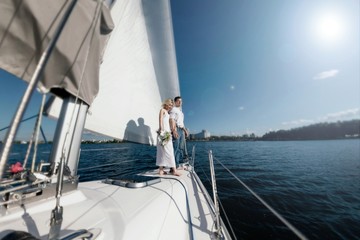 A couple in love on a yacht. A married couple is traveling by sea on a boat. White sails